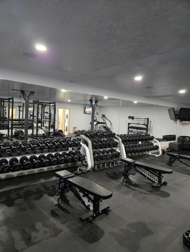 Iron Edge Fitness interior showing full dumbbell racks, squat racks, and cardio equipment in a clean, well-lit space
